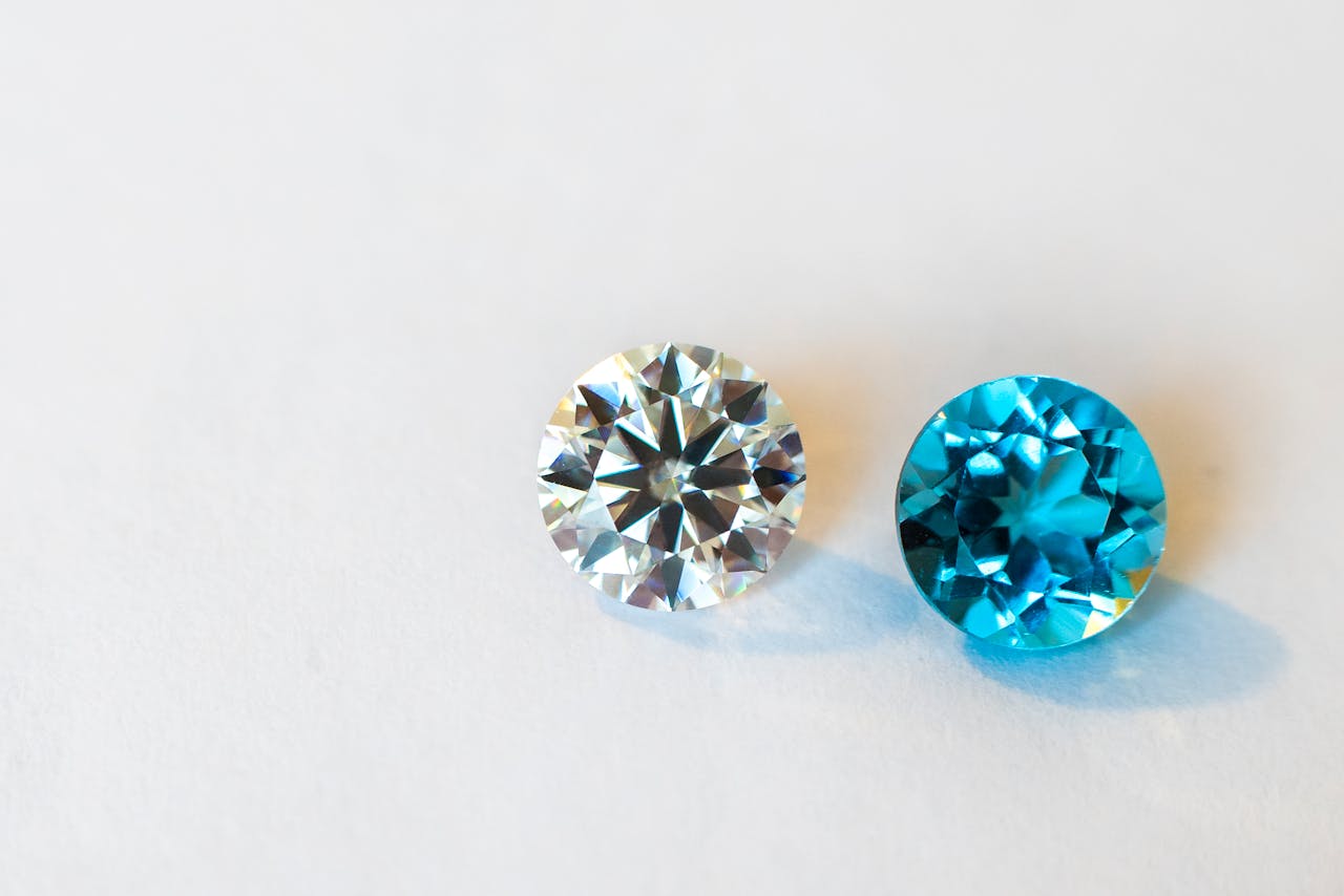 Vivid close-up of a round diamond paired with a stunning blue gemstone, showcasing brilliance.